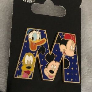 M PIN With Disney Characters on it